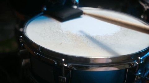 Nahaufnahme einer Snare-Drum mit aufgelegten Drumsticks im Studiolicht