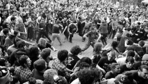 Schwarz-weiße Aufnahme eines dicht gedrängten Moshpits mit tanzenden Fans